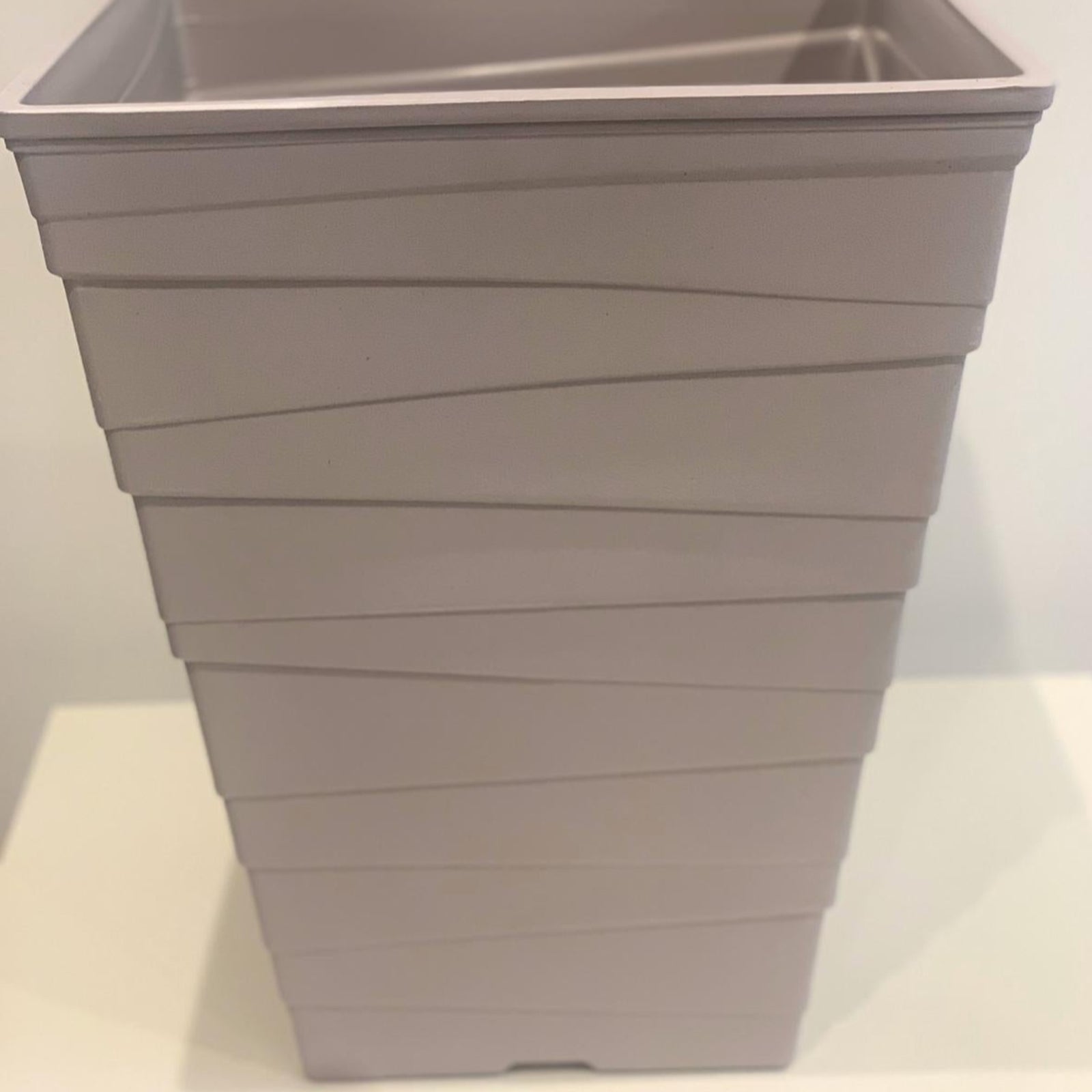 The Luxury Ripple Plastic Plant Pot - GREY is a tall, light gray rectangular pot with horizontal wavy lines, displayed on a white surface against a plain background.